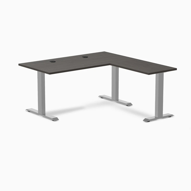 Burnished wood laminate L-shape office desk with gray steel frame and grommets.