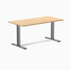 Desky Zero fixed height office desk with Sublime Teak laminate top, Space Gray steel frame, and grommets.