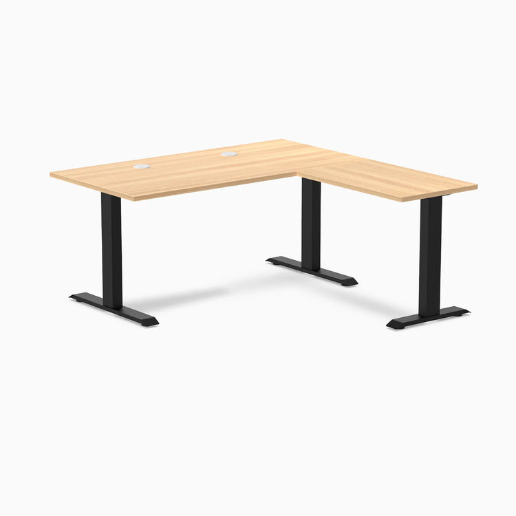 Desky Zero L-shape office desk with Sublime Teak laminate top, matte black steel frame, and grommets.