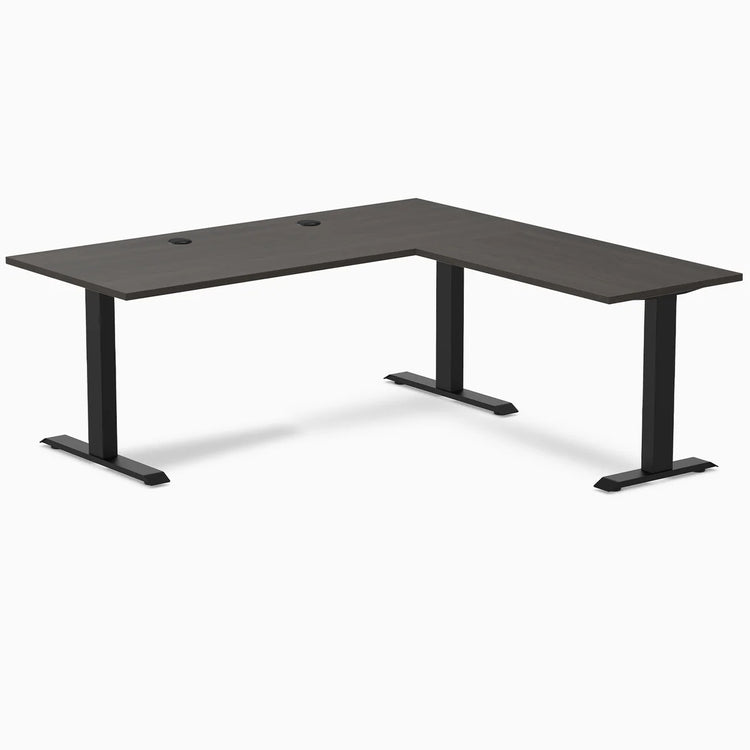 Burnished wood L-shape office desk with matte black steel frame and grommets.