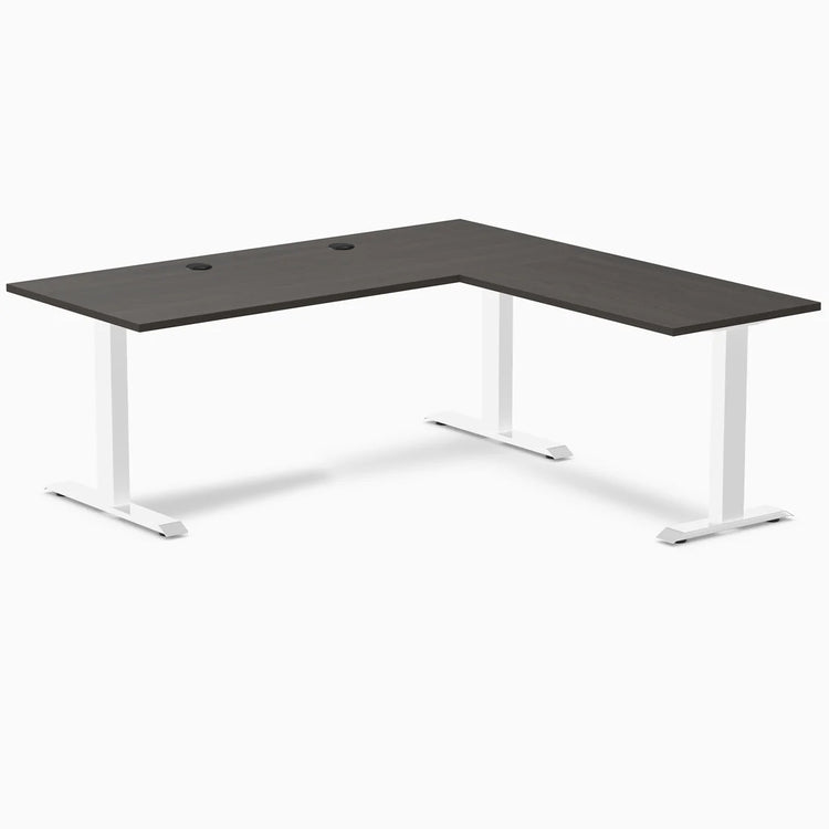 Desky Zero L-shape office desk with burnished wood laminate top, white steel frame, and grommets.