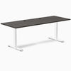 Desky Zero fixed height office desk with burnished wood laminate top, white steel frame, and grommets.