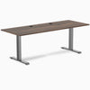 Desky Zero fixed height office desk with Jarrah Legno laminate top, Space Gray steel frame, and grommets.
