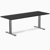 Desky Zero fixed-height office desk with black laminate top, space gray steel frame, and two grommets.