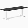 Desky Zero fixed-height office desk with black laminate top, white steel frame, and two grommets.