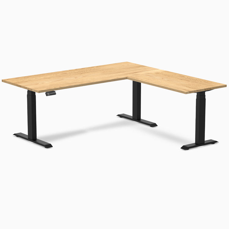 White Oak L-Shape sit-stand desk with matte black legs and control panel.
